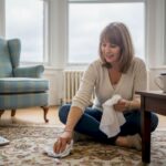 Woman blotting carpet stain in Glasgow living room