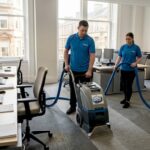 Cleaning crew using carpet machine in office