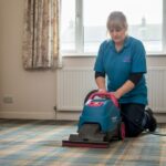 Woman deep cleaning Glasgow living room carpet